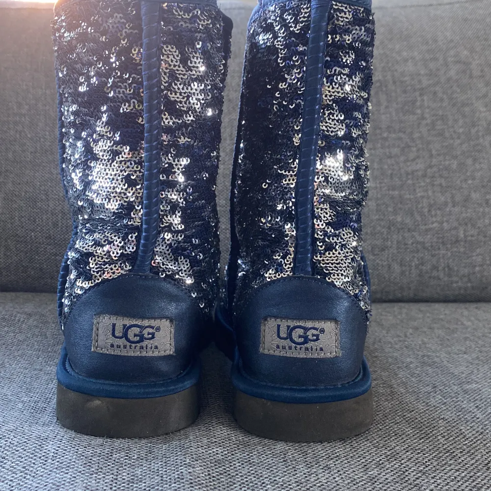 Säljer ett par supercoola UGG boots i blått med glittriga paljetter över hela ytan. De är fodrade med mjukt och varmt foder, perfekt för kalla dagar. Sulan är robust och ger bra grepp. Dessa boots är både snygga och bekväma, idealiska för vinterns alla äventyr! ✨. Kengät.