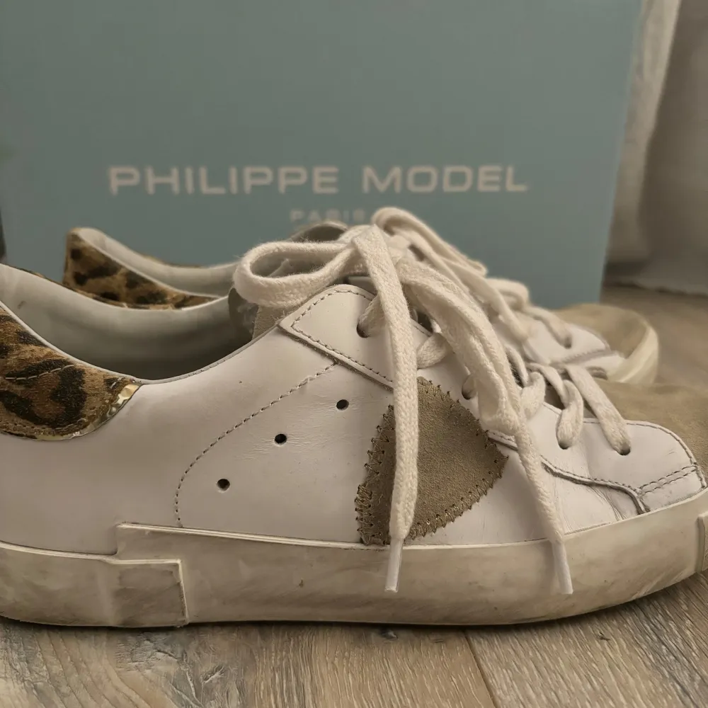 Säljer mina as snygga Philippe Model sneakers i vitt skinn med coola leoparddetaljer på hälen. Skorna har snörning och en snygg beige mockadetalj på sidan. Köpta för ca 3 månader sedan, men använda ca 5 ggr. Säljer då de inte kommer till användning. Pris kan diskuteras😇. Skor.