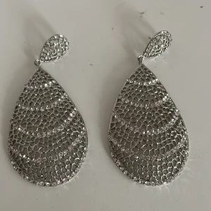 Glittriga silverörhängen i droppform - Säljer ett par superfina glittriga örhängen i silver. De är droppformade och har ett vackert mönster som reflekterar ljuset perfekt. Perfekta för fest eller en utekväll när du vill glänsa lite extra! ✨