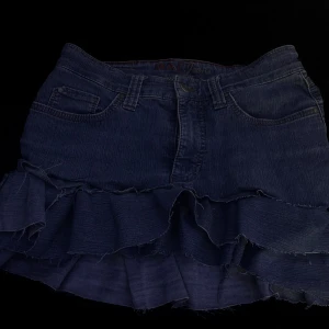 Jeanskjol med volanger MAC Jeans - Säljer en superfin jeanskjol från MAC Jeans i hyfsat skick. Den har volangdetaljer . Perfekt för både vardag och fest! Kjolen har fickor både fram och bak, och en bekväm passform med rhinestones på bakfickorna men 3 stycken har ramlat av + jag har själv fixat två snören där fram så den går och knyta åt.Hör av er för fler frågor🤗