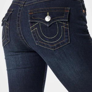 Mörkblå bootcut jeans - Säljer ett par snygga mörkblå bootcut jeans från True Religion. De har coola detaljer med kontrastsömmar och silverfärgade knappar på bakfickorna. Jätte fin passform. Helt nya. Lappen kvar  
