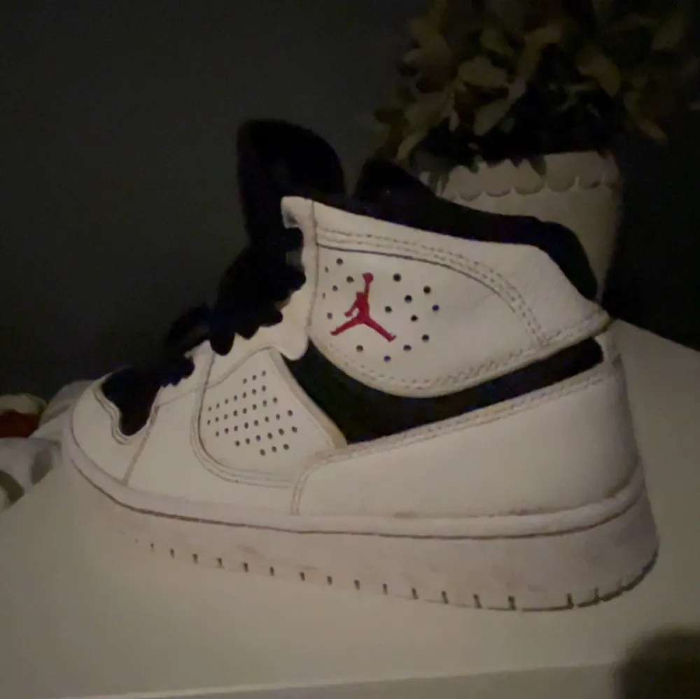 Säljer ett par Nike Air Jordan sneakers i vitt och svart med röda detaljer. Skorna har snörning och är i bra skick. Perfekta för både vardag och sportiga aktiviteter. De är bekväma och stilrena, en klassiker i garderoben! Dom är lite sönder vid tårna som du ser i första bilden skick 8/10. Skor.