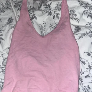Rosa linnetopp från H&M - Säljer en söt rosa linnetopp från H&M i storlek XS. Toppen har en v-ringad design och är perfekt för sommardagar. Den är gjord i ett mjukt material som är skönt mot huden. Passar både till vardags och festliga tillfällen!