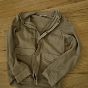 Beige jacka med knappar - Säljer en beige jacka i oanvänt skick. Perfekt till våren eller hösten.