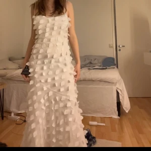 Vit långklänning med volanger - Säljer en fantastisk vit långklänning med volanger över hela klänningen. Den är perfekt för studenten eller  bal. Endast använd en gång. Köpt för 800kr