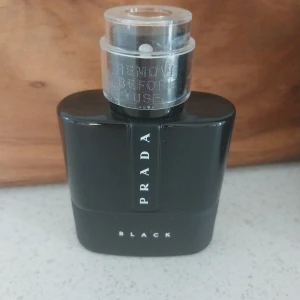 Prada parfym, helt ny.  - Säljer en elegant och stilren Prada Black parfym. Flaskan är svart med en modern design och har en genomskinlig kork. Perfekt för den som vill ha en sofistikerad doft som passar både dag och natt. En lyxig touch till din parfymkollektion!