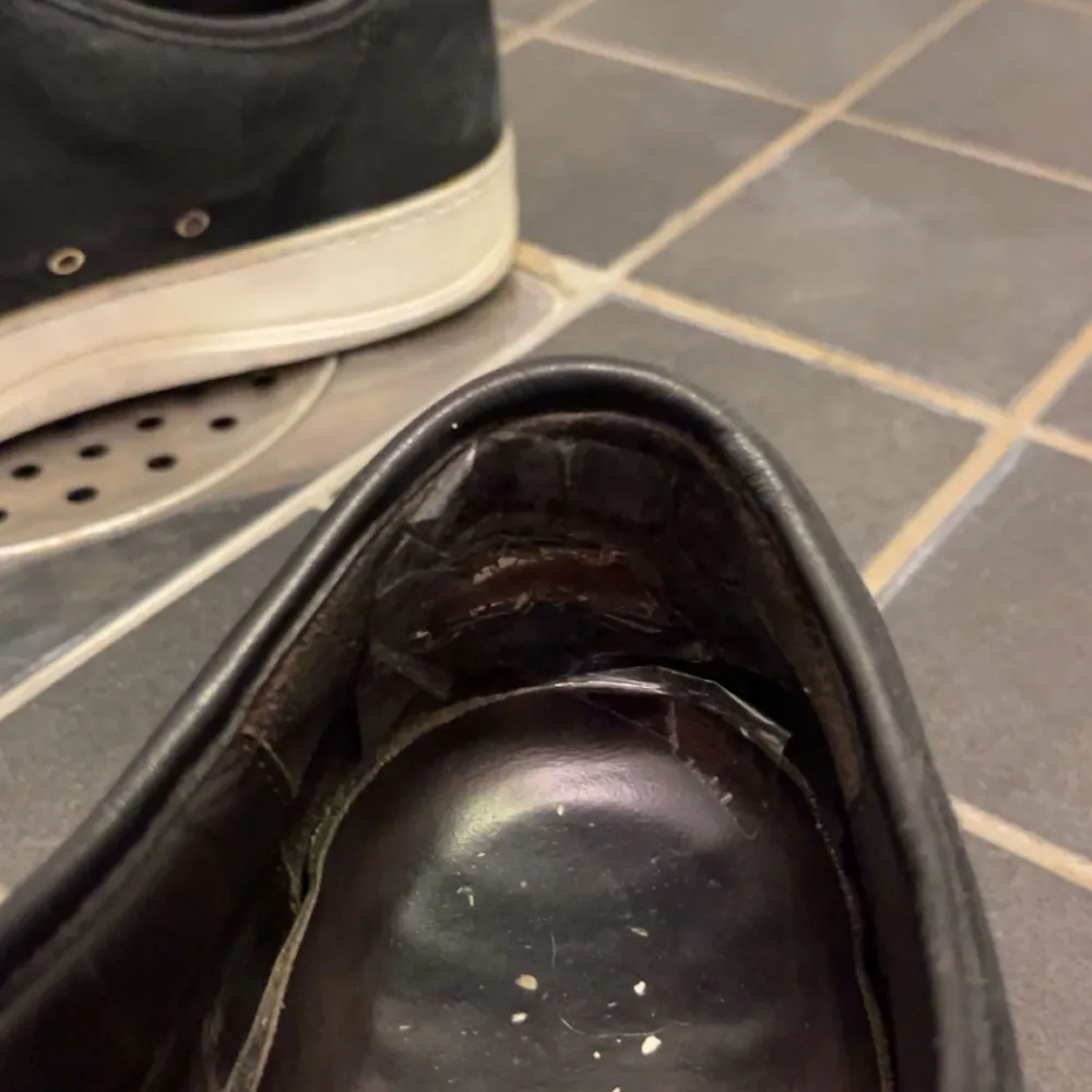 Säljer ett par svarta sneakers i bra skick. De har en glansig tå och snörning framtill. Sulan är vit och lite smutsig, men skorna är annars i fint skick. Perfekta för vardagsbruk och passar till det mesta. Skostorleken är 7, o är som ca 42-43 vanlig storlek. Skor.