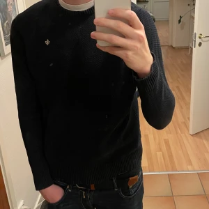 Stickad tröja från Morris  - Säljer en snygg mörkblå stickad tröja från Morris. Tröjan är lite urtvättad men annars i bra skick!Perfekt för både vardag och lite finare tillfällen. Passar bra till jeans eller chinos! Storleken är L men lutar åt M hållet.