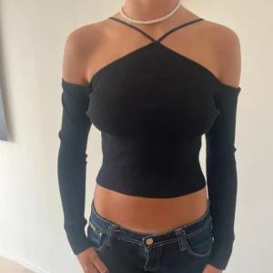 Svart offshoulder topp - Snygg svart offshoulder topp med långa ärmar och en croppad passform.