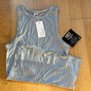 Gråblå ärmlös topp från NLY  - Säljer en snygg grå ärmlös topp från NLY Trend i storlek M. Toppen är i nytt skick och gjord av mjuk viskos med lite stretch för en bekväm passform. Perfekt som ett basplagg i garderoben. 🩶säljer pga fel storlek 