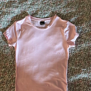 Rosa t-shirt från Gina Tricot - Säljer en söt rosa t-shirt från Gina Tricot,är i mycket bra skick, helt oanvänd då ja köpt fel storlek💕