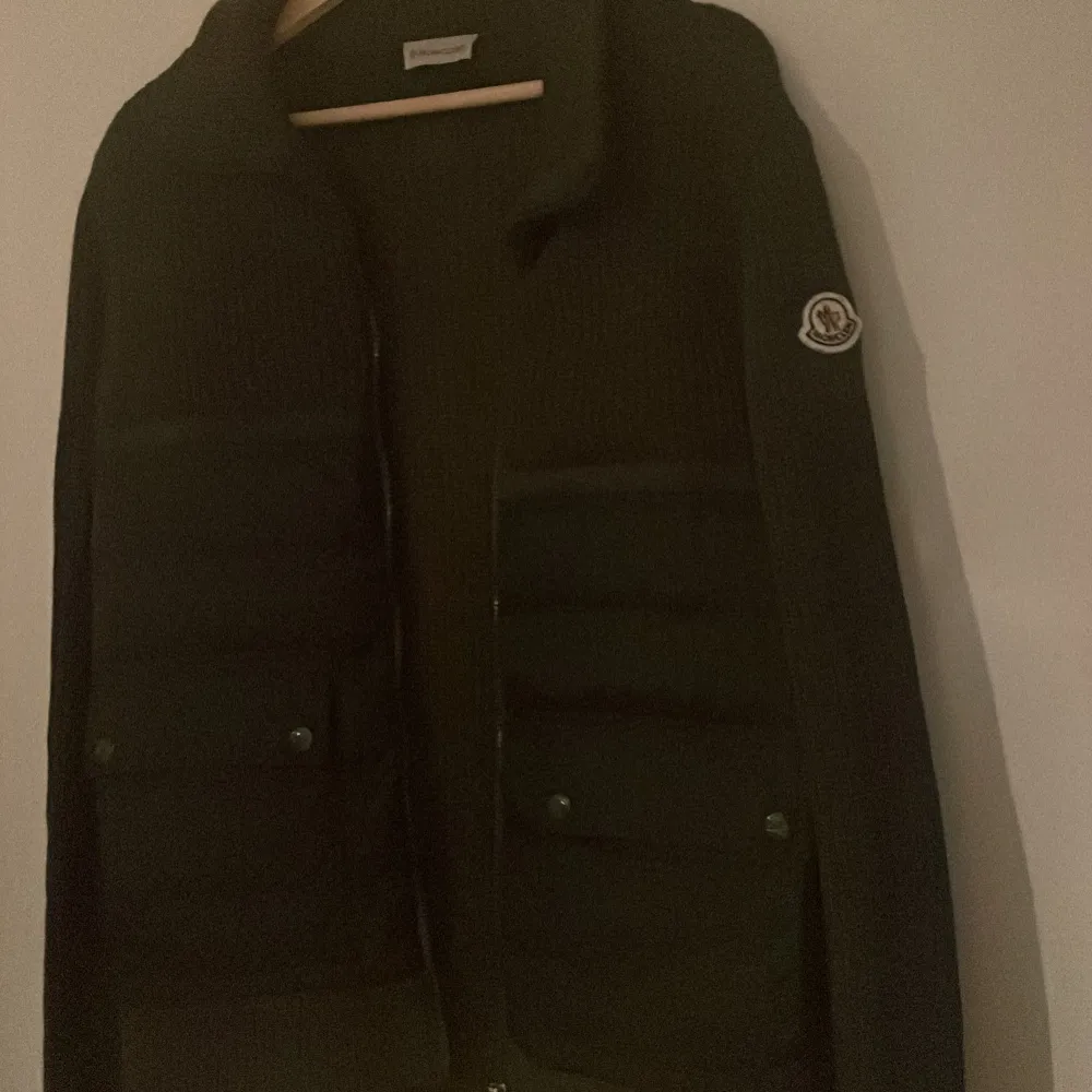 Säljer en snygg grön jacka från Moncler. Den har en quiltad design med långa ärmar och en dragkedja framtill. Perfekt för höst och vinter, med Monclers ikoniska logga på ärmen. Jackan är både stilren och funktionell. NFC funkar såklart. Jackor.