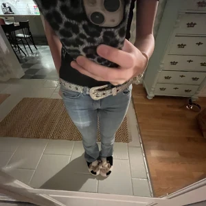 Silver glittrigt bälte - Snygg svart topp med glittrigt fjärilsmönster framtill. Toppen har korta ärmar och en bekväm passform, perfekt för en utekväll eller fest. Den är i bra skick och passar till både jeans och kjol. En riktig garderobsfavorit!