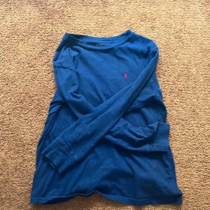 Blå långärmad tröja från Ralph Lauren - Säljer en snygg blå långärmad tröja från Ralph Lauren. Använd fåtal gånger pågrund av för stor