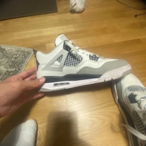 Nike Air Jordans military black  - Säljer ett par snygga Nike Air Jordans i vitt och svart. Skorna har en klassisk design med snörning och den ikoniska Jumpman-loggan på tungan. Perfekta för både vardag och fest! De är i mycket bra skick och redo för en ny ägare. Dem är tyvär inte äkta dock