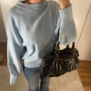 Ljusblå stickad tröja - Säljer en superfin ljusblå stickad tröja som är perfekt. Den har en avslappnad passform med långa ärmar och ribbade kanter. Från Lovies. Små defekter längst ner men inget som märks!🤍🤍