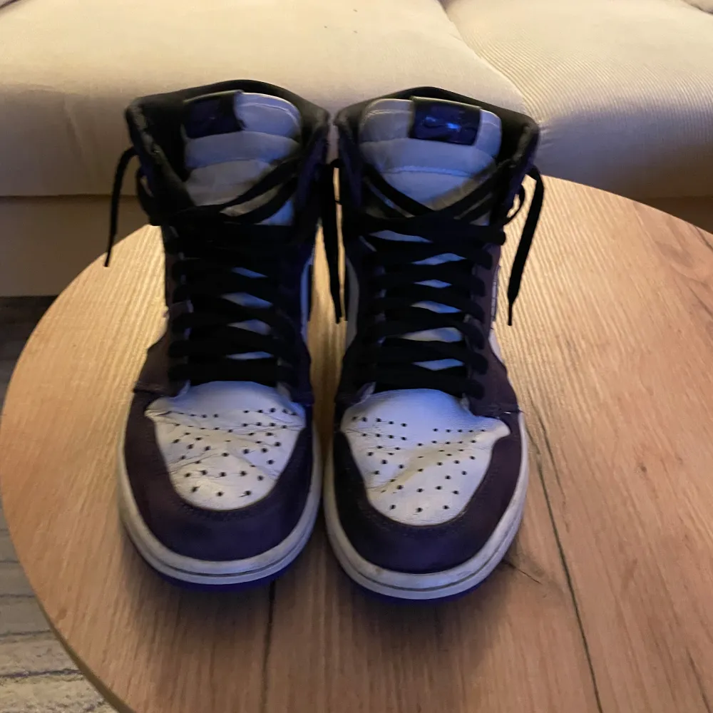 Jordan 1 high.    Lila och vita, köpte för unge för 1 år sedan. Har knappt använt själv, dom är rätts så kressade från förra ägaren. Där av priset. Skor.