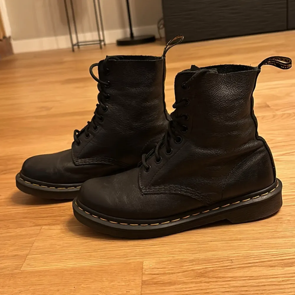 Säljer ett par klassiska svarta boots i skinn med snörning. De har en robust design och är perfekta för höst och vinter. Skorna är i bra skick och har en bekväm passform. Perfekta för både vardag och fest!. Skor.