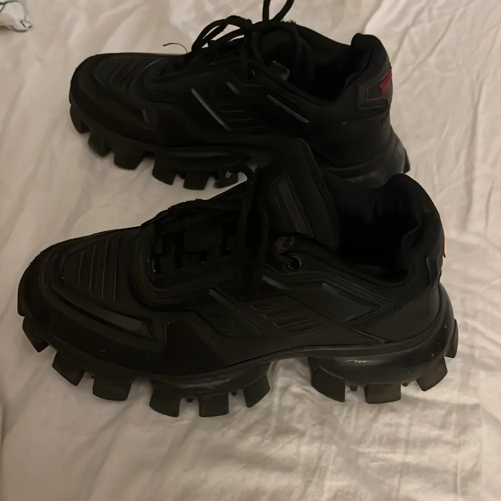 Säljer ett par svarta Prada Cloudbust Thunder sneakers. Original pris. 10 309kr. Strl 41 men passar även strl 42. Perfekta till vardags men även till utgång! . Skor.