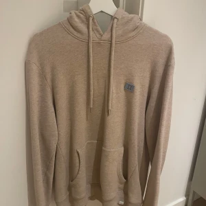 Beige hoodie från les deux - Säljer en supermjuk beige hoodie från les deux i storlek M. Den har en klassisk känguruficka och justerbar dragsko i huvan. Perfekt för mysiga höstkvällar eller som ett lager under jackan. Använd ett fåtal gånger, så den är i mycket bra skick. Passar både till vardags och chill.
