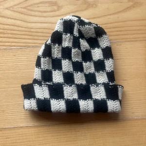 Svartvit rutig mössa från Sundays - Stickad Snygg och trendig svartvit rutig mössa från Sundays. Perfekt för att hålla värmen under kyliga dagar. Ett måste för garderoben!