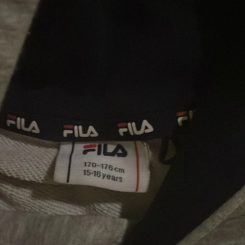 Säljer en snygg och bekväm grå hoodie från FILA. Perfekt för både vardag och chill. Den har en klassisk design med FILA-loggan i rött och blått på bröstet. Passar perfekt för höst och vår. Passar även för dom som är 160cm. Tröjor & Koftor.