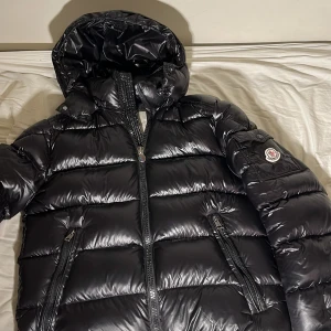 Svart pufferjacka  Moncler,  - Säljer en snygg svart pufferjacka från Moncler i mycket bra skick. Jackan har en glansig finish och är perfekt för vintern. Köpt 1 vecka sedan och kände att den inte passar min still. Köpt för 2500. Säljs för 2000. Pris kan diskuteras…. ( Vid snabb äffar 1800KR ) Passar alla 170-185 cm