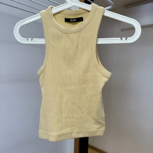 Gult linne från Bik Bok - Säljer ett snygg linne från Bik Bok. Superbekväm och lätt att matcha med olika outfits!