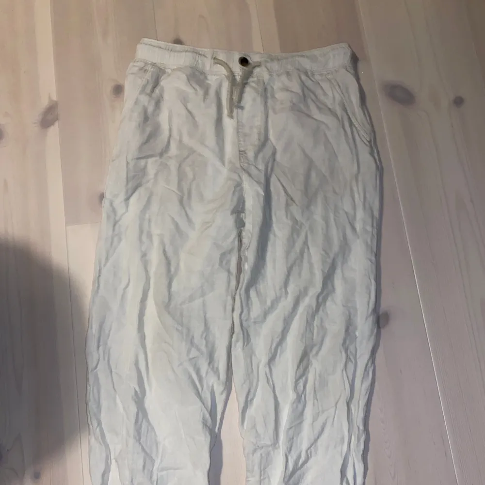 Säljer ett par bekväma beige linnebyxor från h&m med elastisk midja och snörning. Perfekta för sommardagar eller avslappnade tillfällen. Byxorna har en loose passform och är i bra skick. Perfekta för en chill dag på stranden eller en promenad i parken.. Jeans & Byxor.