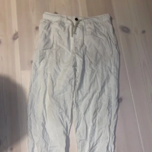 Beige linnebyxor med snörning - Säljer ett par bekväma beige linnebyxor från h&m med elastisk midja och snörning. Perfekta för sommardagar eller avslappnade tillfällen. Byxorna har en loose passform och är i bra skick. Perfekta för en chill dag på stranden eller en promenad i parken.