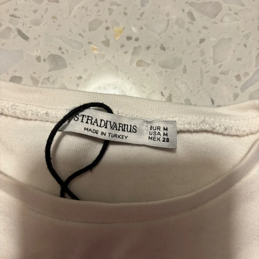 Säljer en vit t-shirt från Stradivarius med texten 'I ❤️ BREAKING HEARTS' i svart och rött. Den är kortärmad och gjord i bomull, perfekt för en avslappnad stil. Passar bra till både jeans och kjol!. T-shirts.