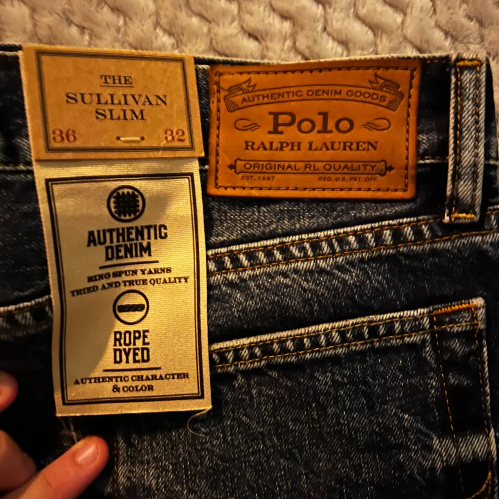 Säljer ett par snygga blå jeans från Polo Ralph Lauren i modellen Sullivan Slim. De har en cool slitning och dragkedja fram. Perfekta för både vardag och fest! Varing Byxor är väldigt små i storlek. . Jeans & Byxor.