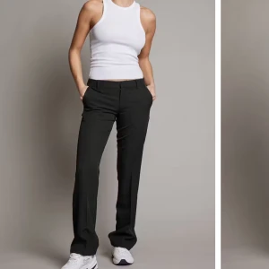 Svarta kostymbyxor - Snygga svarta kostymbyxor i modellen ”Vera”. Perfekta för både vardag och fest. De har en klassisk och stilren design som passar till allt. Byxorna är i ett bekvämt material som ger en skön passform. Dessa är köpta för originalpris och säljer för 400kr pga ingen användning av de (strl 34).