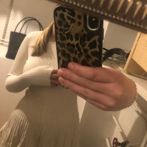 Vit ribbad klänning från FB Sister - Säljer en superfin vit ribbad klänning från FB Sister. Den har en tight passform med långa ärmar och är perfekt för både vardag och fest. Materialet är mjukt och stretchigt, vilket gör den bekväm att bära hela dagen. Skulle säga att det är en vinterklänning men passar lika bra till höst och sommar. Jag är 167 cm lång och den går precis över rumpan.