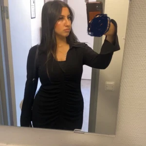 Svart långklänning H&M - Snygg svart långklänning i mycket nyskick . Den har långa ärmar och en stilren krage. Klänningen har en knapprad framtill och en elegant rynkad detalj som ger en smickrande passform. Fårn H&M✨