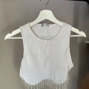 Vit ribbad linnetopp ZARA - Superfin vit ribbad linnetopp från Zara, snygg pärldetalj längst er. Toppen är i bra skick och passar perfekt till fest. Storlek M-L men passar S, liten i storleken 