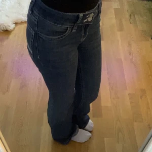 Lådmidjade jeans med broderade bakfickor - Säljer ett par snygga mörkblå jeans med låg midja och broderade detaljer på bakfickorna. 