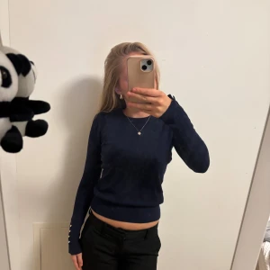 Mörkblå tröja med knappar - Säljer en snygg mörkblå tröja med långa ärmar och stilrena knappar vid ärmsluten. Perfekt för både vardag och fest! Tröjan är i bra skick och passar till det mesta. Skön och enkel att matcha med andra plagg. Hör av dig vid intresse! 💙