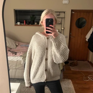 Beige stickad kofta med knappar - Mysig beige stickad kofta med stora knappar framtill. Den har en avslappnad passform och långa ärmar. Koftan sticks inte!