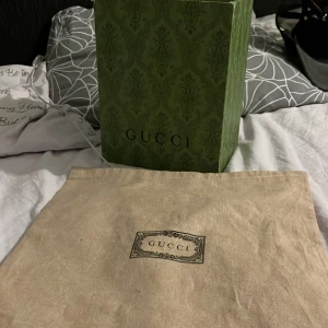 Gucci snake keps - Säljer en snygg svart keps från Gucci med ett coolt ormmönster i rött och vitt. Kepsen har ett nätmaterial på baksidan för bra ventilation och justerbar passform. Perfekt för att ge din outfit en lyxig touch! 🐍