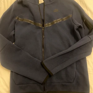 Marinblå Nike tech jacka - Säljer nu min super snygga nice tech tröja då den inte kommer till användning💗mycket bra skick och inga defekter💞passar för både kvinnor och män