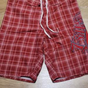 Säljer ett par snygga röda rutiga shorts från Billabong. De har en cool broderad logga på sidan och snörning i midjan för perfekt passform. Perfekta för sommardagar på stranden eller vid poolen. 🏄‍♂️