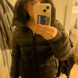 Olivgrön pufferjacka peak - Säljer en olivgrön pufferjacka i mycket bra skick(helt oanvänd eftersom jag tycker den sitter lite kans på mig jag e för kort.)Den har en dragkedja framtill och en stor huva för extra värme. Perfekt för kalla vinterdagar. Jackan är från peak performance och har en normal passform. Supermysig och stilren!