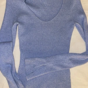 Blå ribbad tröja från H&M - Säljer en superfin blå ribbad tröja från H&M i storlek XS. Den har en snygg v-ringning och långa ärmar, perfekt för både vardag och fest. Tröjan är i mycket bra skick och passar perfekt till höst- och vårgarderoben. Skön och stretchig, så den sitter riktigt bra!