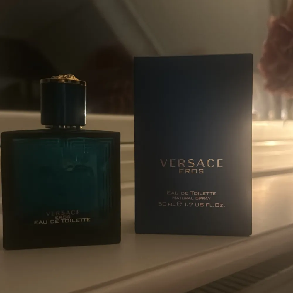 Säljer en flaska Versace Eros Eau de Toilette, 50 ml. Flaskan är i en snygg turkosblå färg med guldiga detaljer på korken. Perfekt för den som vill ha en fräsch och maskulin doft. Kommer med originalförpackning. Passar både till vardags och fest!. Parfym.