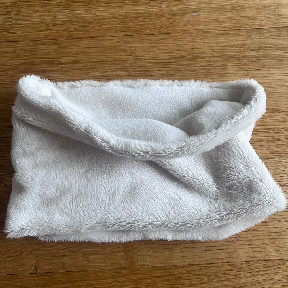 Supermjuk och fluffig vit buff som är perfekt nu till vintern både inne och ute! Den är i ett mjukt tyg på utsidan och varm microfleece fordring. Egensydd.. Muu.