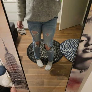 Ljusa slitna jeans från LAB Industries - Säljer ett par ljusa jeans från LAB Industries i bra skick. De har en cool, sliten look med stora revor på knäna och låren. Perfekta för en avslappnad och trendig stil. Passar bra till både vardags och fest!