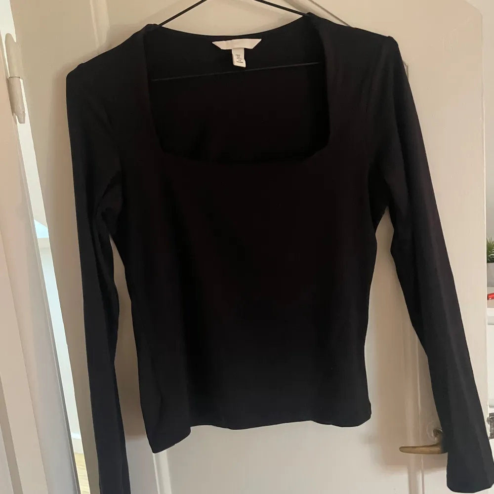 Säljer en stilren svart långärmad topp från H&M. Den har en fyrkantig urringning och är perfekt för både vardag och fest. Toppen är i superbra skick och passar till alla säsonger. Perfekt att matcha med jeans eller kjol!. Neuletakit & Villapaidat.