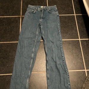 Blå jeans från Dobber - Säljer ett par klassiska blå jeans från Dobber i storlek 38. De har en straight passform och är tillverkade i slitstarkt denim. Perfekta för vardagsbruk och kan matchas med nästan vad som helst. Jeansens tidlösa design gör dem till ett måste i garderoben!