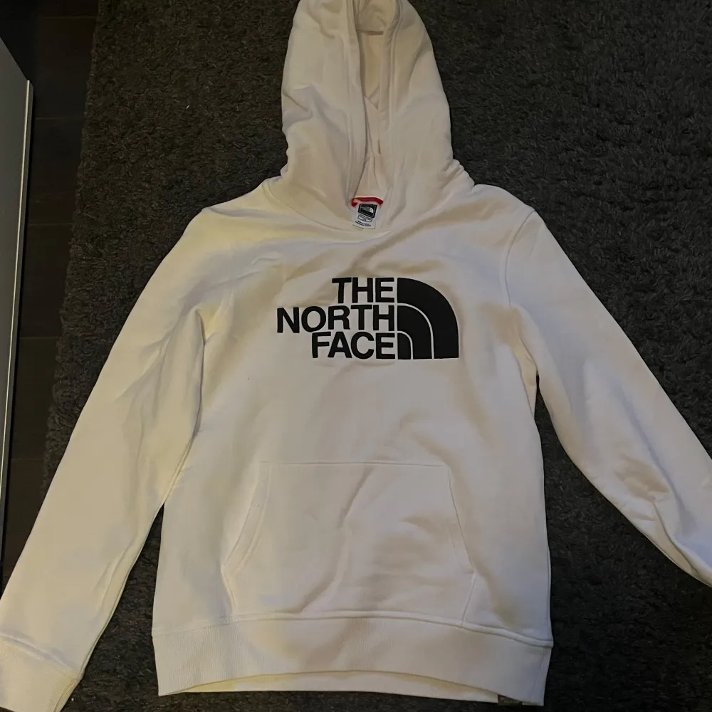 Säljer en snygg och bekväm vit hoodie från The North Face. Den har en stor logga på framsidan. Perfekt för kyliga dagar och som ett vanligt varddagsplagg! Prislappen finns inte kvar men den är helt oanvänd. Oklart vilken storlek det är men skulle tippa på xxs eller 158/164. Nånstans där. Nypris ca 700, mitt pris 550+frakt.. Tröjor & Koftor.